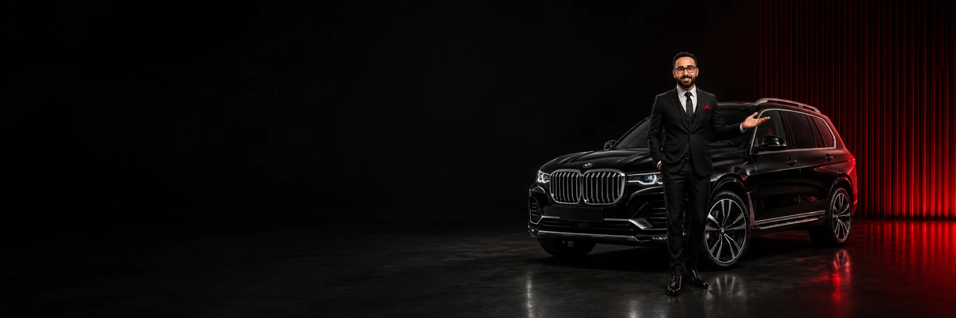 Motorista da LocaVip em traje formal ao lado de BMW X7 preta