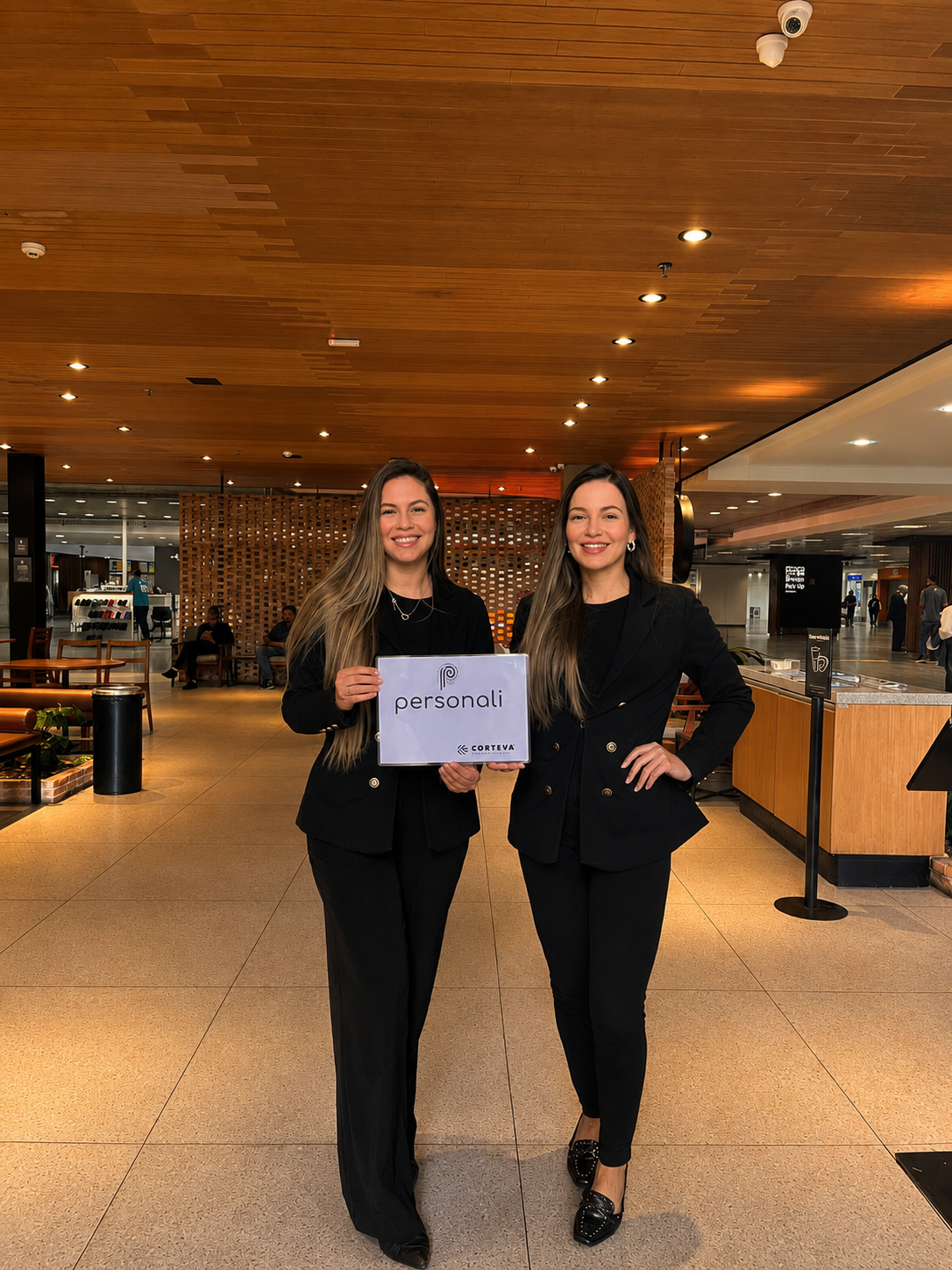 Equipe de recepção Loca Vip com placa de atendimento corporativo